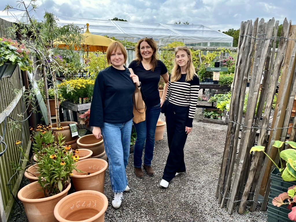 Zdjęcie przedstawie trzy kobiety na tle farmy - uczestniczki wyjazdu.